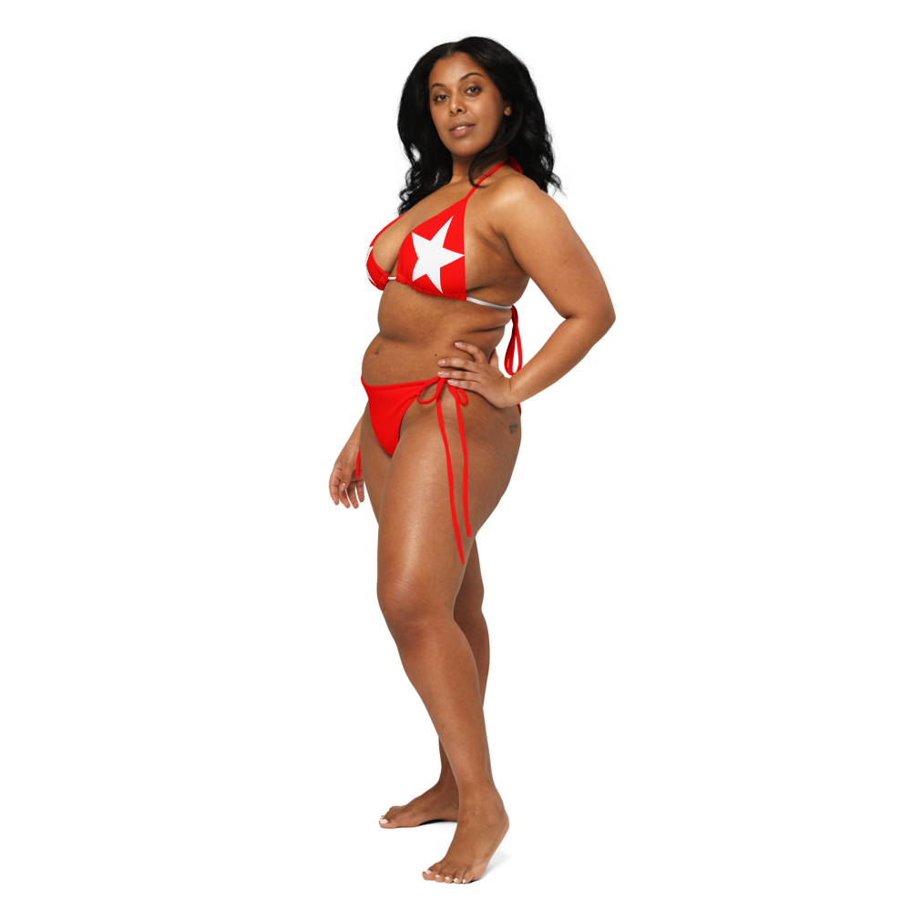 Model wearing Nova Star – Red bikini, front view, with red triangle top and white star graphics, paired with string-tie bottoms.