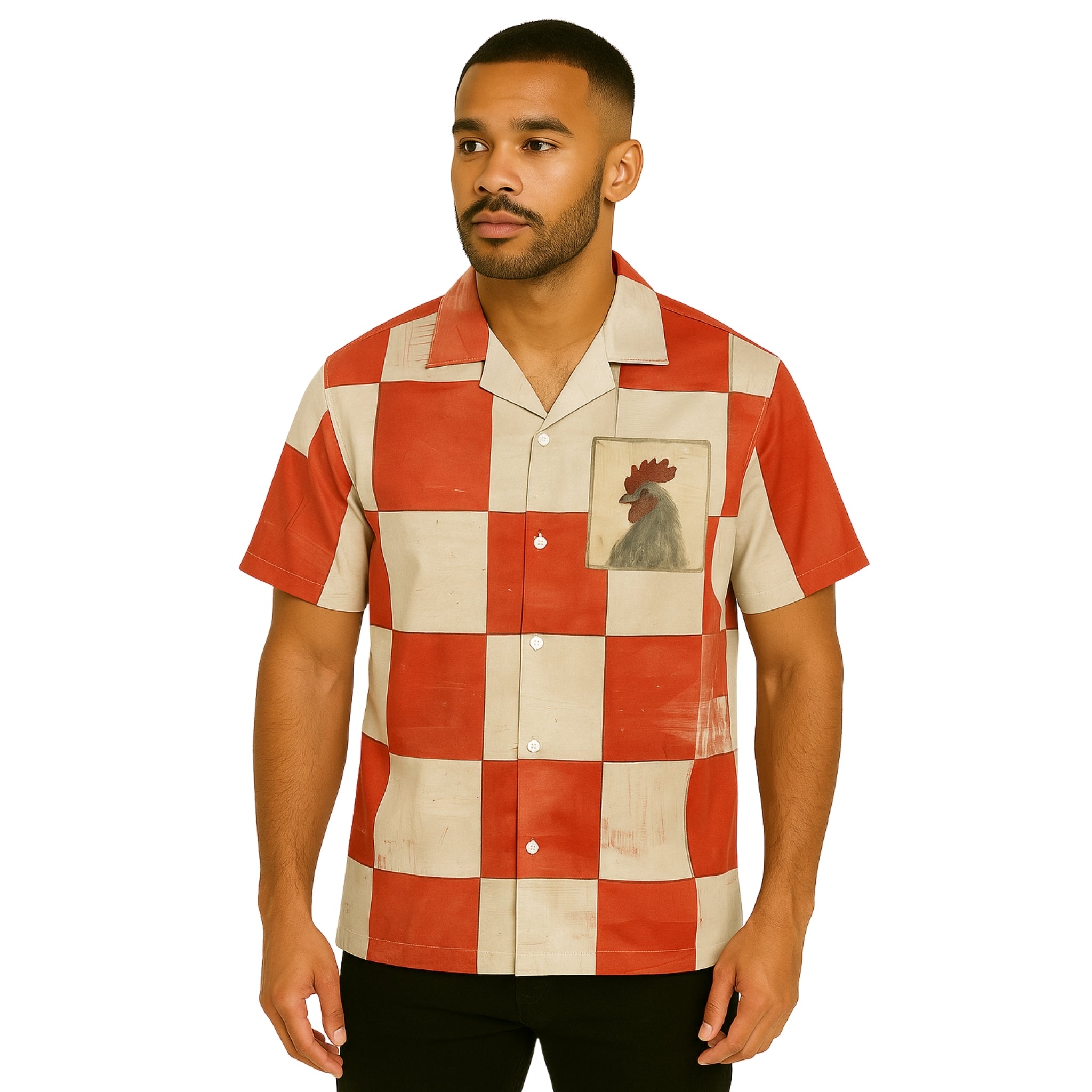 Model wearing Breakin' Atoms "Big Rooster Shirt," a short-sleeve dress shirt with oversized red and cream checkerboard print and a bold rooster graphic on the chest pocket.
