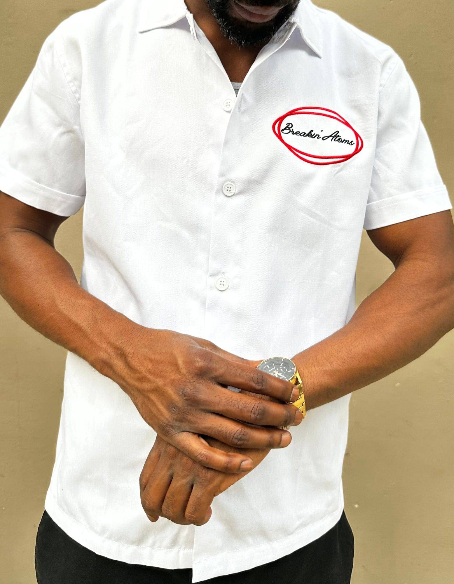 Model wearing Breakin' Atoms "Work Shirt," a structured short sleeve button-up inspired by classic utility and mechanic shirts, featuring durable fabric and embroidered logo details — built for function and streetwear form.