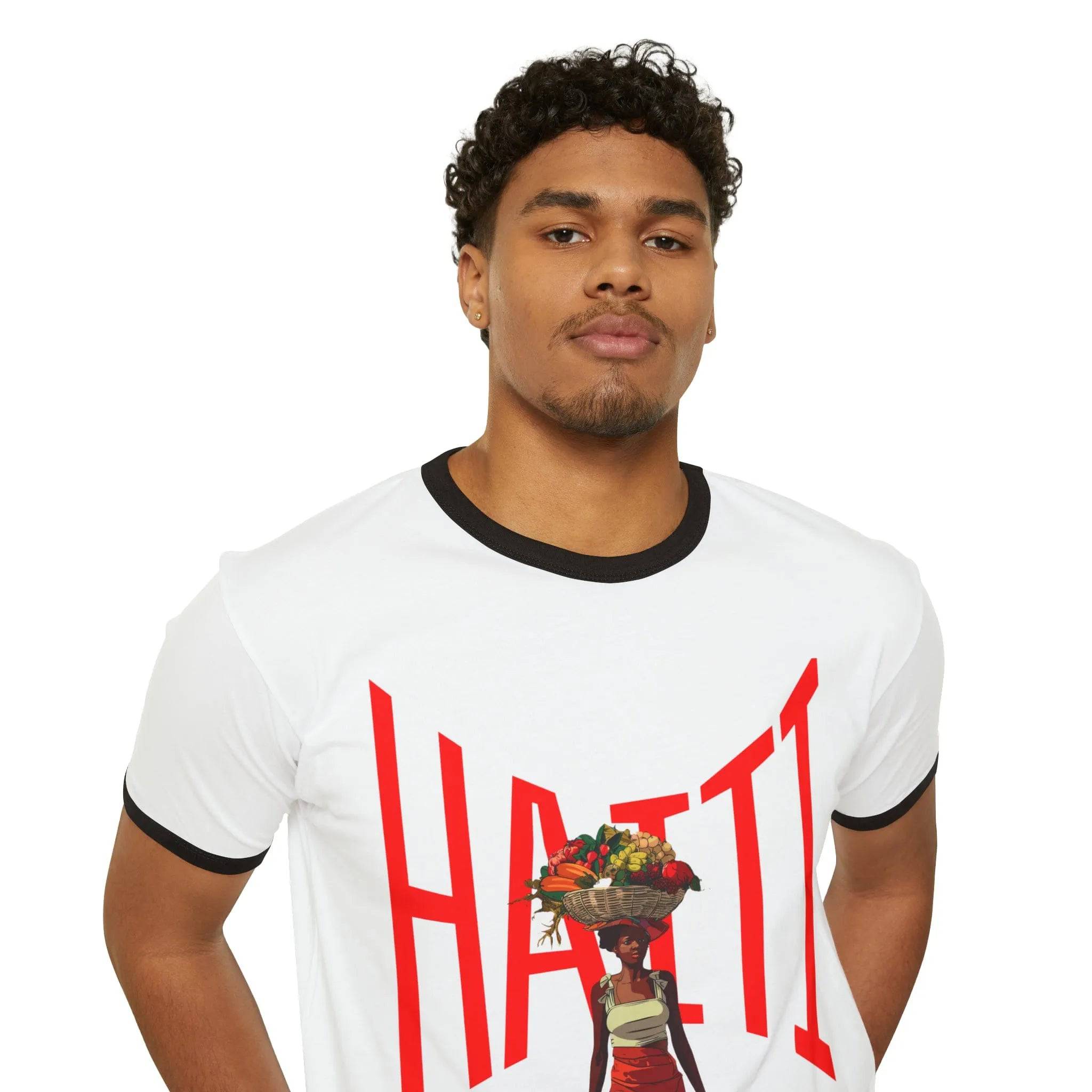 Model wearing Breakin' Atoms "Heritage Pride Ringer Tee – Haitian Beauty Edition," a cropped off-white tee with black collar and sleeve trim, featuring bold red "HAITI" lettering and silhouette graphic of a Haitian woman in traditional attire.