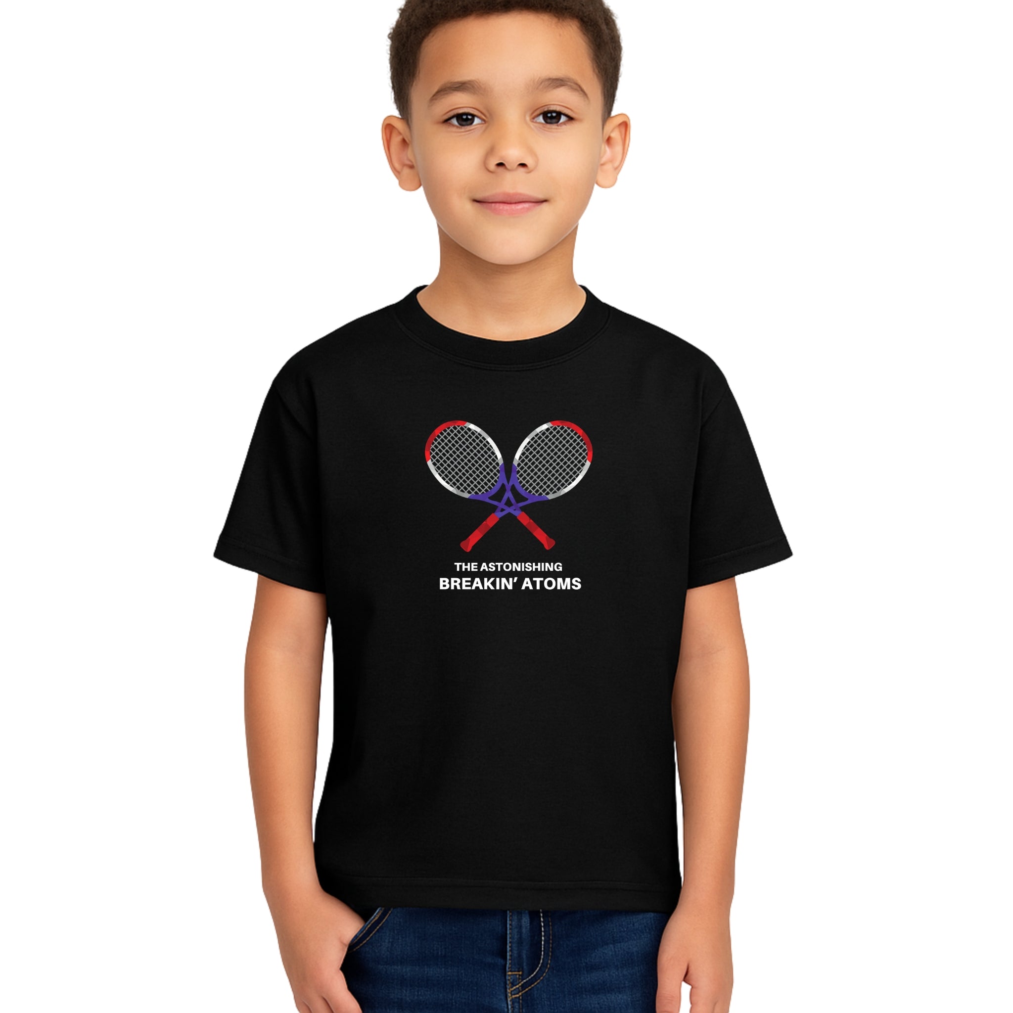 Child model wearing Breakin' Atoms Kid's Tennis Tee in black, featuring crossed tennis rackets and bold text design — a fun, sporty graphic t-shirt perfect for active kids and tennis fans.