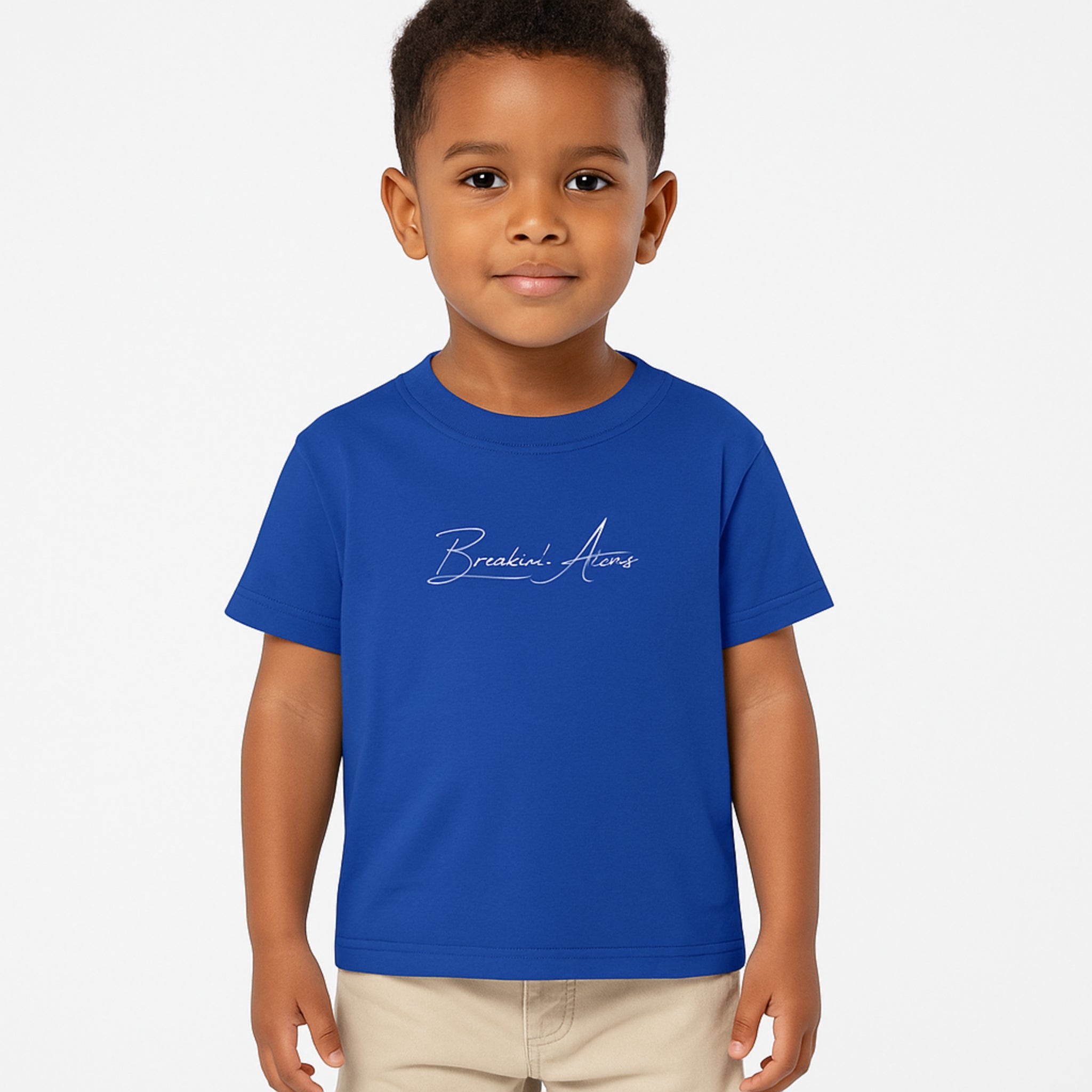 Child wearing Breakin' Atoms "The Little Voyager Tee," a kids’ graphic t-shirt featuring a whimsical space travel design that celebrates curiosity, creativity, and big dreams.