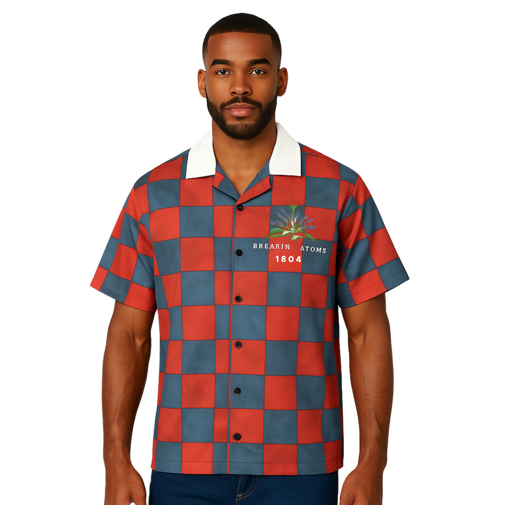 Model wearing Breakin' Atoms "Liberation 1804 Button-Up," a short sleeve shirt honoring the Haitian Revolution, featuring rich blue, red, and black tones and cultural motifs symbolizing freedom and resistance. — Breakin Atoms premium streetwear