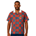 Model wearing Breakin' Atoms "Liberation 1804 Button-Up," a short sleeve shirt honoring the Haitian Revolution, featuring rich blue, red, and black tones and cultural motifs symbolizing freedom and resistance. thumbnail 1